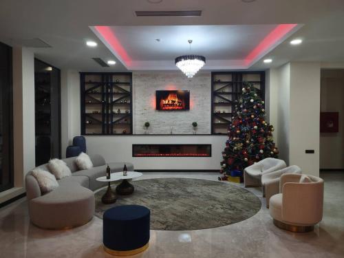 a living room with a christmas tree and a fireplace at Olympus Hotel By Umbrella in Tbilisi City