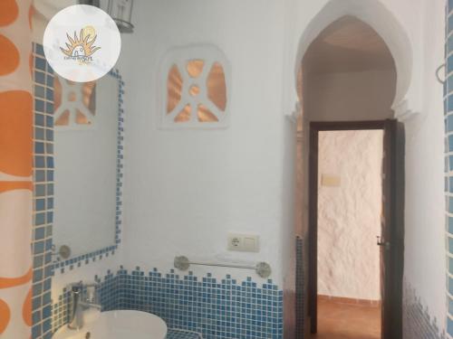 Gorafe的住宿－Cuevas del Sol，浴室配有水槽和蓝色瓷砖墙。