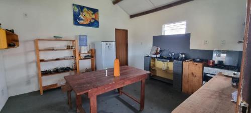 Casa do ET caraiva xando في بورتو سيغورو: مطبخ مع طاولة خشبية عليها شمعة