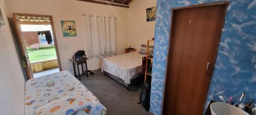 Habitación con dormitorio con cama y puerta en Casa do ET caraiva xando, en Porto Seguro
