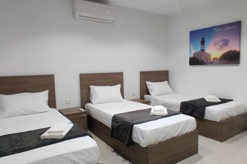 um quarto com três camas e uma fotografia na parede em Apt B : Fun flat for up to 5+ Inc terrace em Is-Swieqi