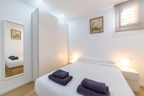 a bedroom with a white bed with two towels on it at Trendy Homes Lepanto II, a 5 minutos de Puerta Purchena in Almería