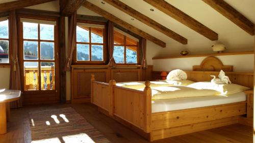 a bedroom with two beds in a room with windows at Gasthof Ochsalm in Kirchberg in Tirol