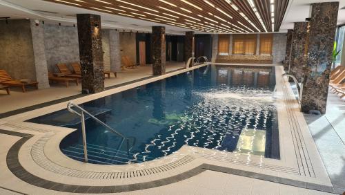 a large swimming pool in a hotel lobby at Sunny Mountain Apartment - Zlatibor, Serbia - SPA & WELLNESS CENTER in Zlatibor