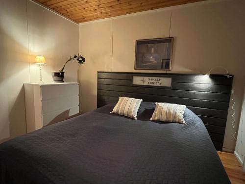 a bedroom with a large bed with a wooden headboard at Tirmo Strand in Porvoo