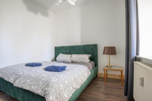 Urige Wohnung mit zwei Betten und genialer Küche في Mügeln: غرفة نوم عليها سرير ووسادتين زرقاوين