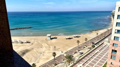 - une vue sur la plage bordée de palmiers et l'océan dans l'établissement Apartment with sea view, à Haïfa