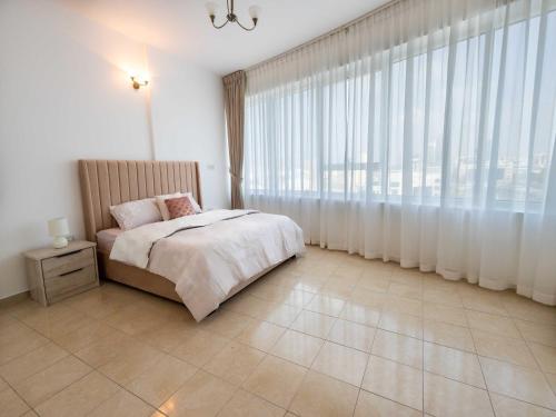 1 dormitorio con cama y ventana grande en Avantha By Afi luxury 2BHK apartment, en Dubái