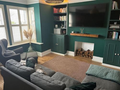 uma sala de estar com um sofá e uma televisão de ecrã plano em Millwright Villa - sleeps 7 em Lincolnshire