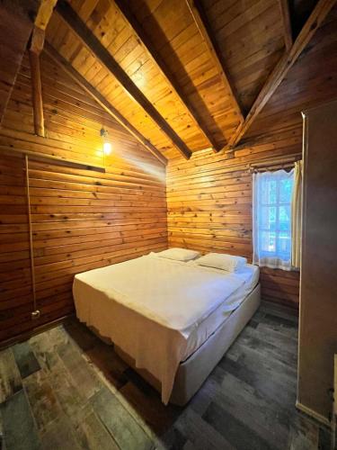 a bedroom with a large bed in a wooden room at Kızılbük Ahşap Evleri in Datca
