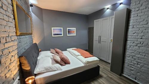 deux lits dans une chambre avec un mur de briques dans l'établissement Apartment Silver 313, à Karlovy Vary