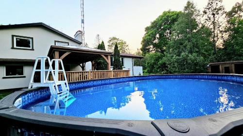 a swimming pool with two chairs in a house at La Datcha 20 Acres Private Spa, with Pool, Jacuzzi & Wood Burning Sauna in Cookstown