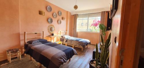 馬拉喀什的住宿－Maison Mamdy，一间卧室设有两张床和窗户。