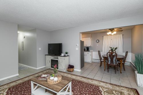 a living room with a table and a dining room at 2 Bedroom Oasis 5 Mins to Mayo Clinic in Rochester