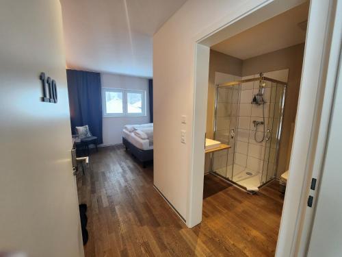 een slaapkamer met een bed en een douche in een kamer bij Pension fein & sein in Schwarzsee