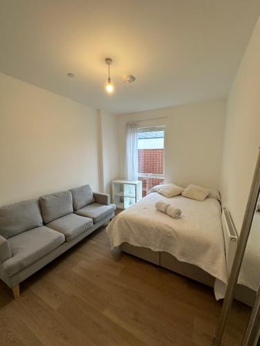 ein Schlafzimmer mit einem Bett und einem Sofa in der Unterkunft King Square Gardens in London
