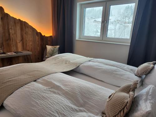 1 dormitorio con 2 camas y ventana en Pension fein & sein, en Schwarzsee