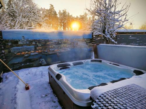 a hot tub on a balcony in the snow at Private apartment suite with sauna themed bedroom, private jacuzzi, city center by train 15min in Helsinki