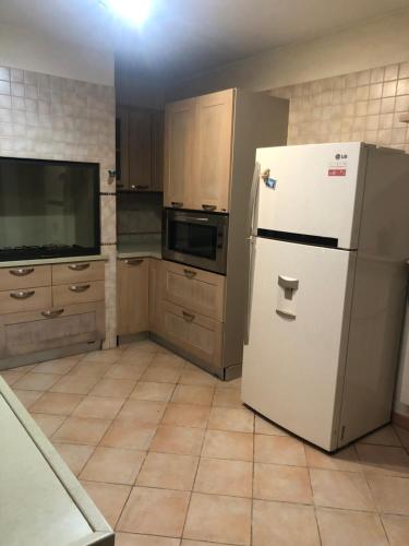 a kitchen with a white refrigerator and wooden cabinets at Casa Sara in Monopoli