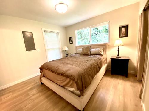 Un dormitorio con una cama grande y una ventana en Creekside Cottage in the City, en Portland