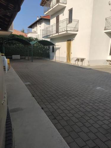 a building with a brick walkway with umbrellas on it at Sonia sweet home in Candelo