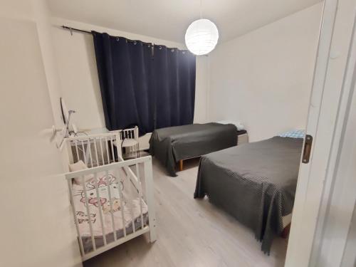 - une petite chambre avec 2 lits et un lit bébé dans l'établissement Hopeahaka kaksio 45 m2, à Kirkkonummi