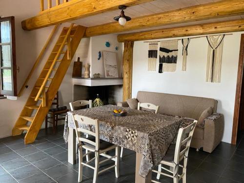 a dining room with a table and chairs and a staircase at Casa Margherita in Càbras