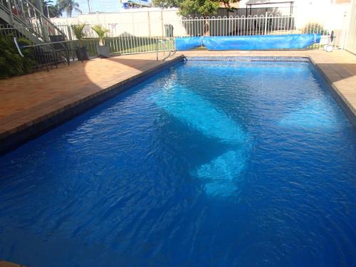 a large blue swimming pool with a water slide at City Colonial Motor Inn in Mildura