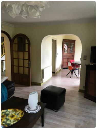 a living room with a couch and a table at Chambre dans maison avec piscine in Brive-la-Gaillarde