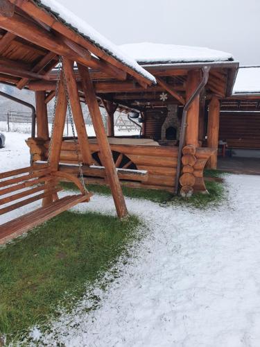 a wooden cabin with snow on the roof at CASA LAURENTIU in Borşa