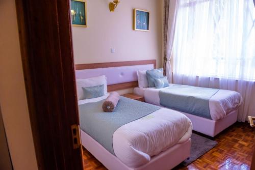 a room with two beds and a couch at Glamour Suites in Nanyuki