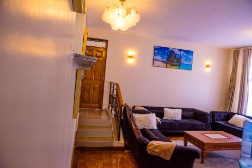 a living room with a couch and a table at Glamour Suites in Nanyuki