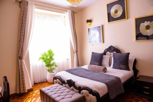 a bedroom with a large bed and a window at Glamour Suites in Nanyuki