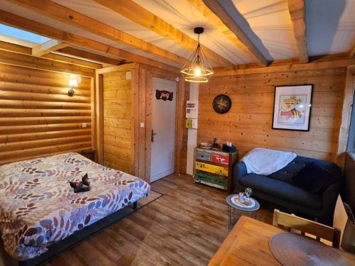 1 dormitorio con 1 cama y 1 sofá en una habitación en Studio type chalet, en Gérardmer