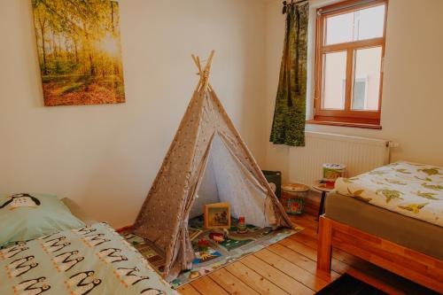 イルメナウにあるFerienwohnung Wanderslust zentral in Ilmenauの部屋の角にテント付きのベッドルーム1室が備わります。