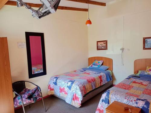 um quarto com 2 camas e uma mesa em Residencial Ortega em Osorno