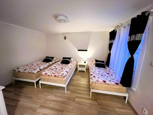 2 camas en una habitación con 2 ventanas en Pod Czereśnią, en Szczecin