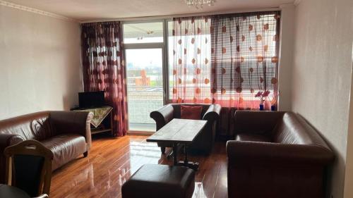 a living room with leather furniture and a table at Top Rheinblick Apartment Neuss - Düsseldorf in Neuss
