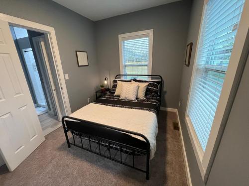 a bedroom with a bed and two windows at Mid Century 1/4 mile to Downtown Main Street - breweries, coffee, dining, shops in Monroe