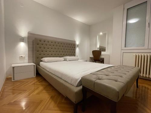 a bedroom with a large bed with a tufted headboard at Luxury Getaway Apartment in Skopje