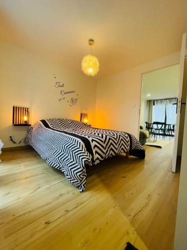 a bedroom with a bed with a zebra print blanket at Charmant T3 des Pyrénées in Argelès-Gazost