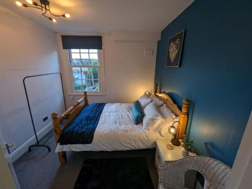 a bedroom with a bed with a blue wall at Avon’s Rest in Stratford-upon-Avon