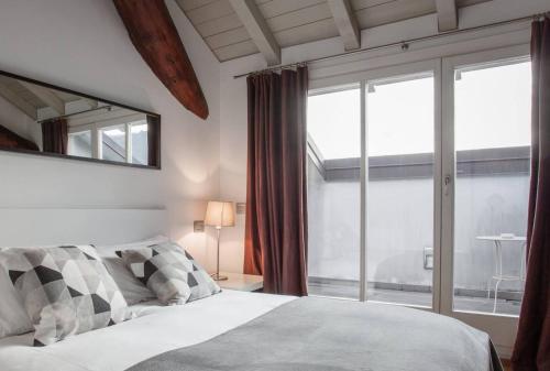 1 dormitorio con cama y ventana grande en Como Sweet Como, en Como