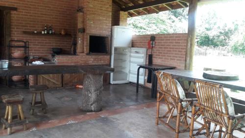 cocina con mesa, sillas y nevera en Espaço Maria Carolina, en São Pedro