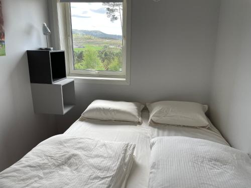 a bedroom with two beds and a window at Cabin near Pulpit Rock in Strand