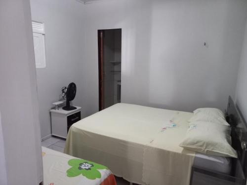una piccola camera con letto e telefono di Chácara Família Nacer a Serra de São Bento