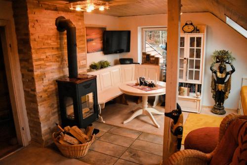 a living room with a wood stove and a table at Ferienwohnung zur Steinklamm im bayrischen Wald in Spiegelau