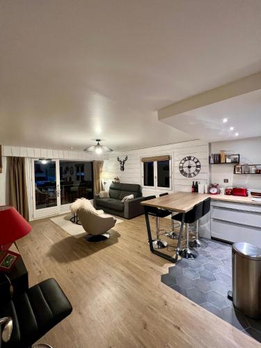 un grand salon avec une table et un canapé dans l'établissement Appart entre lac et montagne, à Saint-Jean-de-Sixt