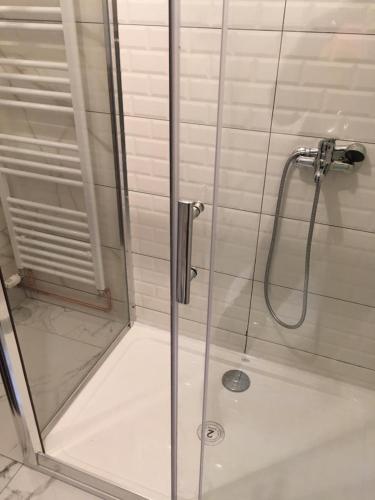 La salle de bains est pourvue d'une douche avec une porte en verre. dans l'établissement Apartman Marija, à Kupres