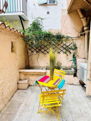 une terrasse avec deux chaises et une table avec une plante dans l'établissement Appartement Cosy, à Perpignan